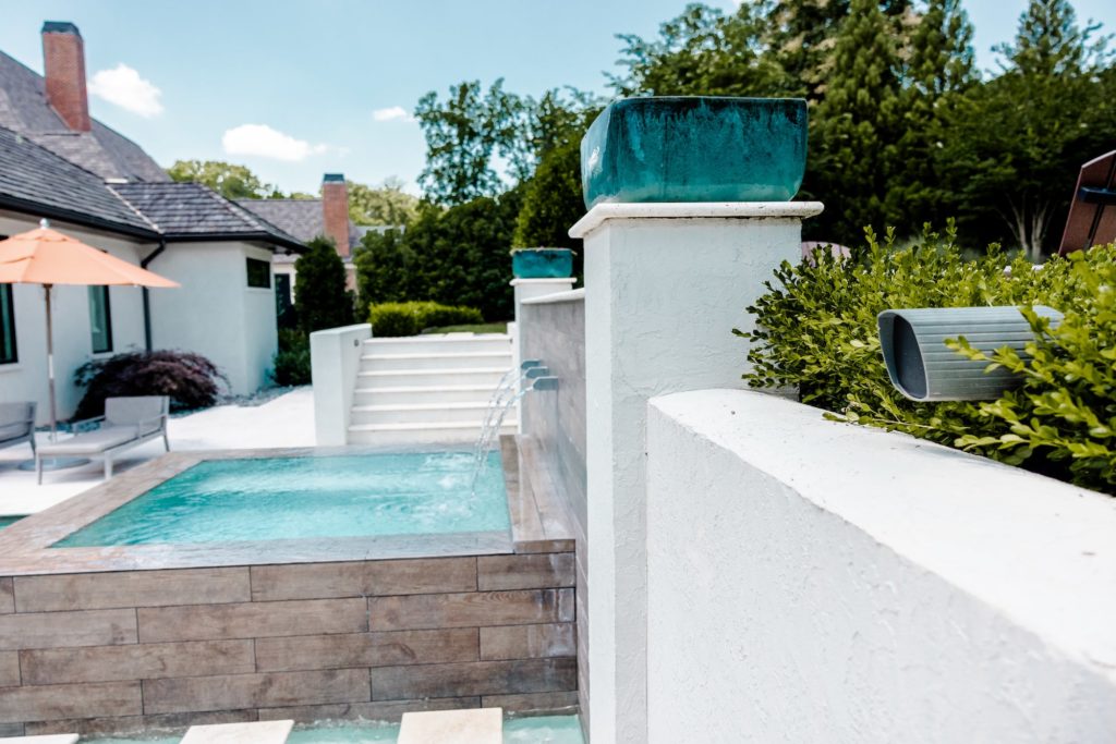 outdoor_entertainment_area_speaker_in_bushes_audio_setup_backyard
